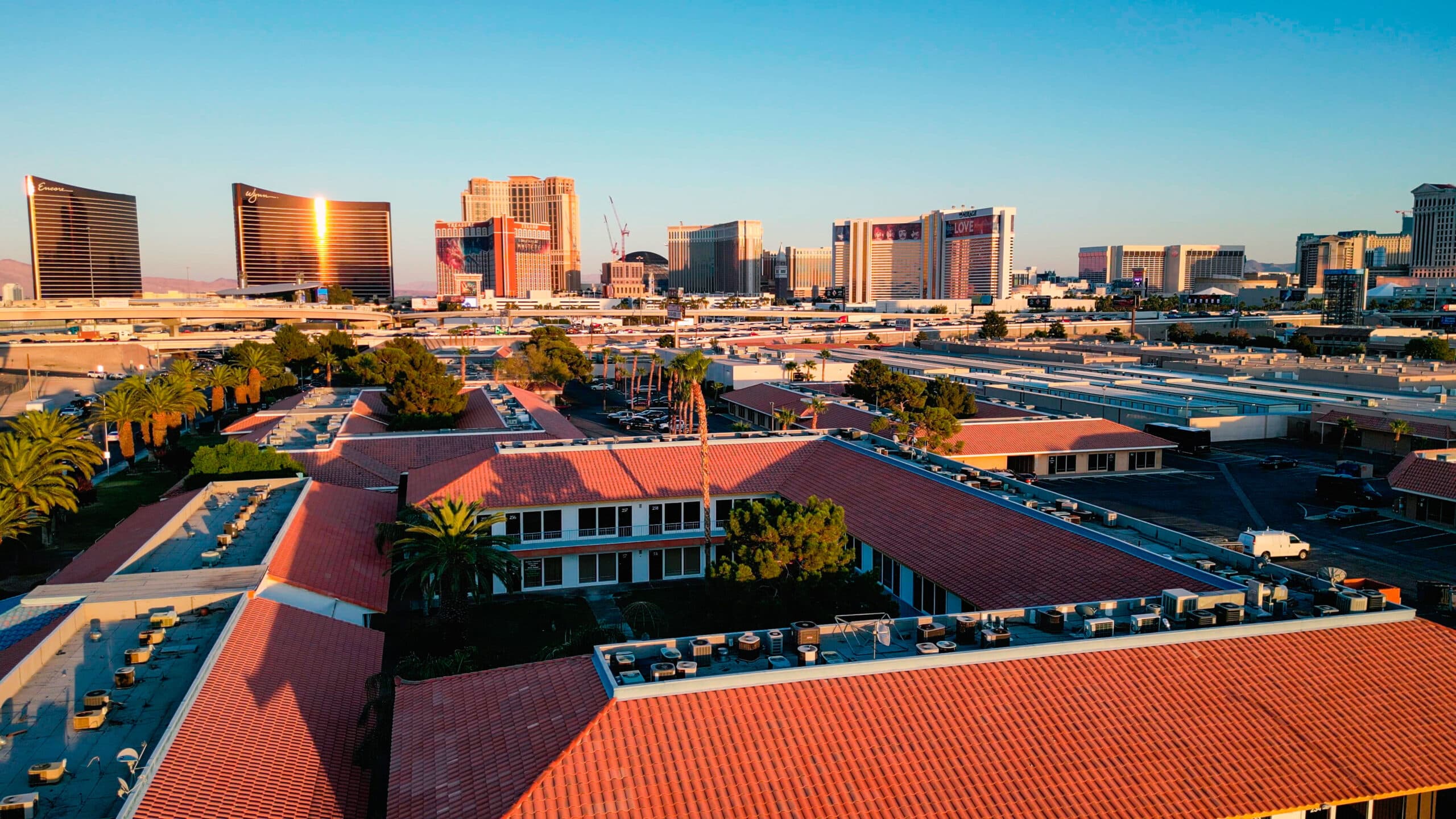 Aerial view of Cowork Lounge's red-tiled rooftops at sunset with the Las Vegas Strip skyline behind